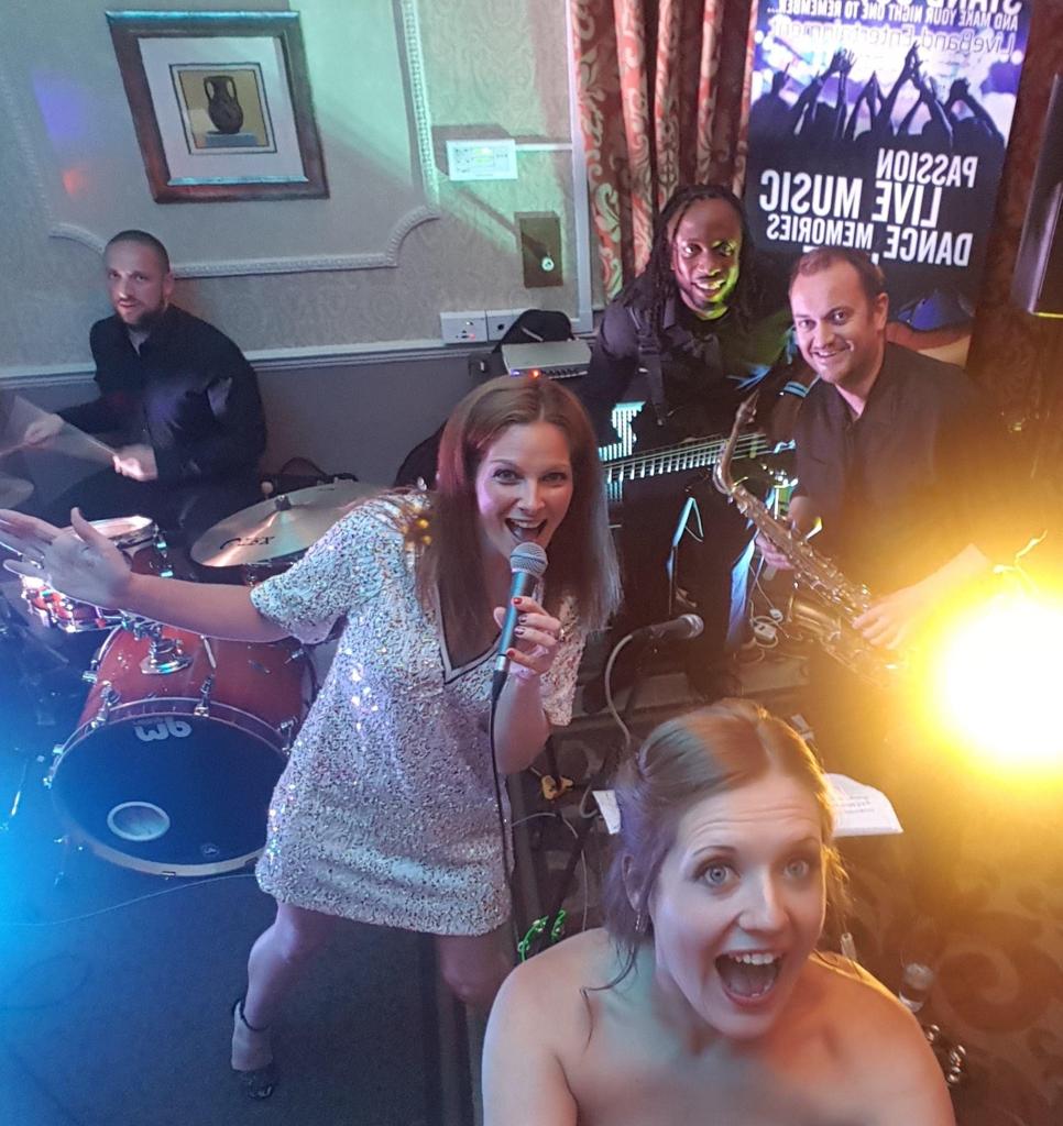Our live 4-piece wedding party band poses with a happy bride. 