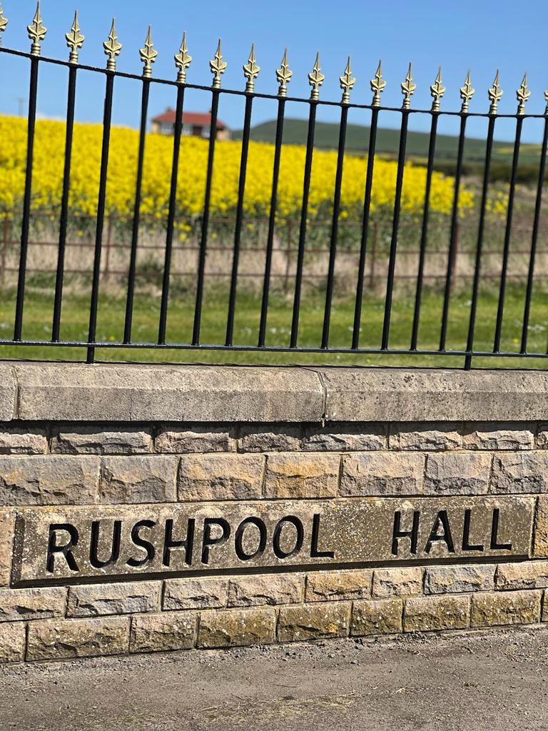 Rushpool Hall's entry gate and sign